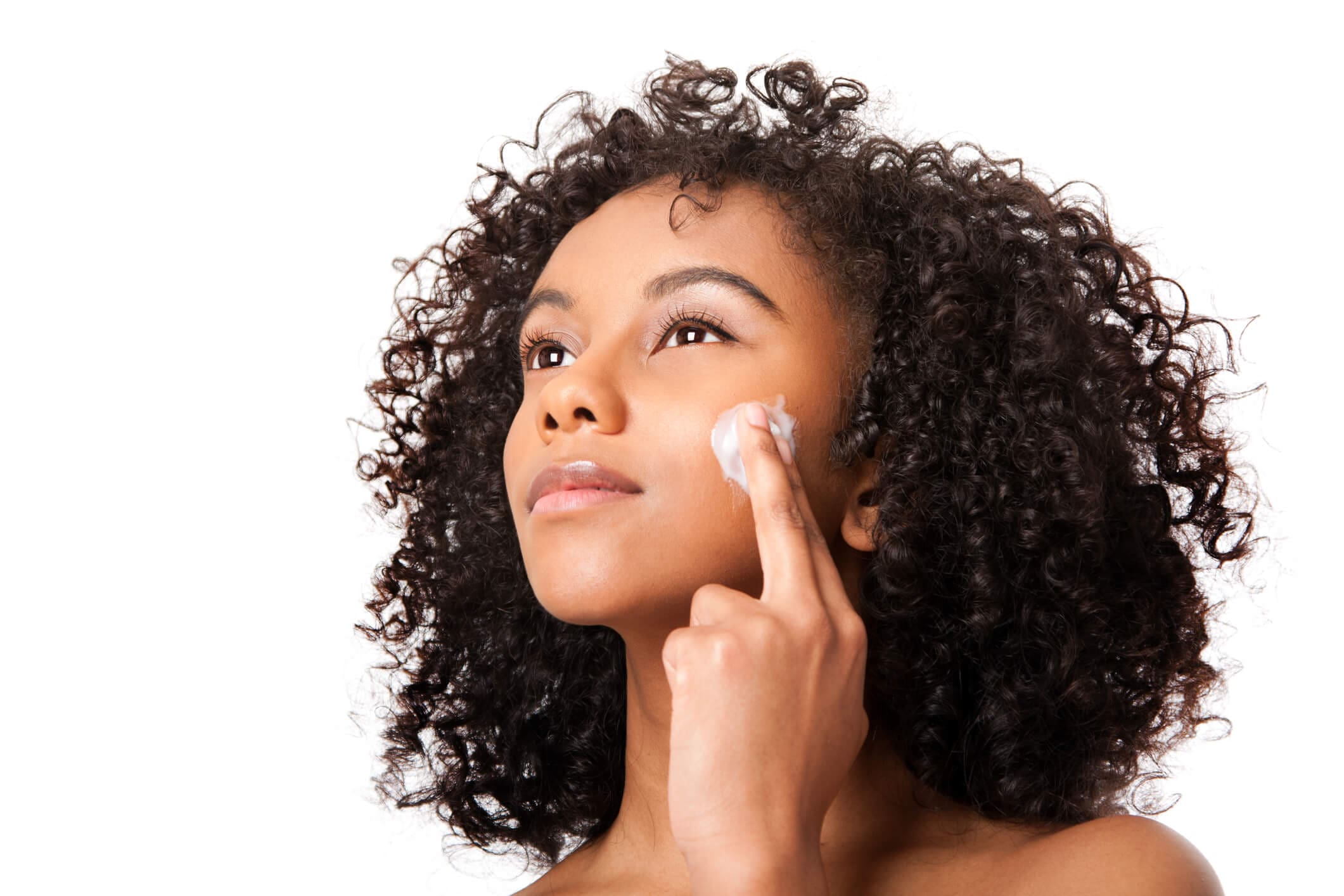 A woman putting cream on her face