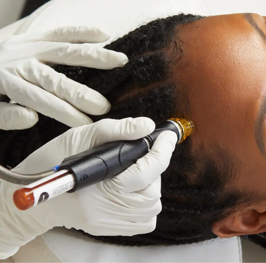 A person getting their hair cut with an electric razor.