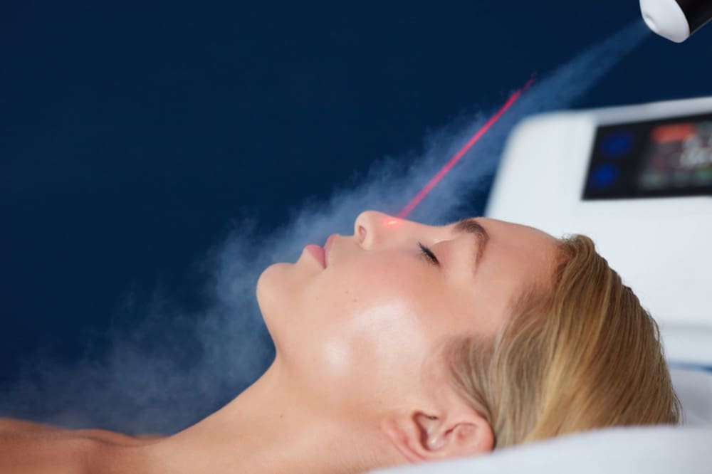 A woman laying down with steam coming out of her face.