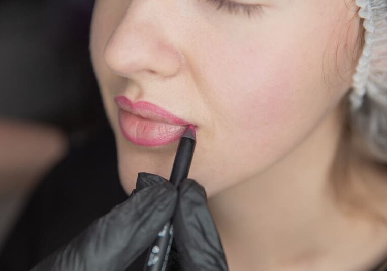 A woman with black gloves on holding onto a pen