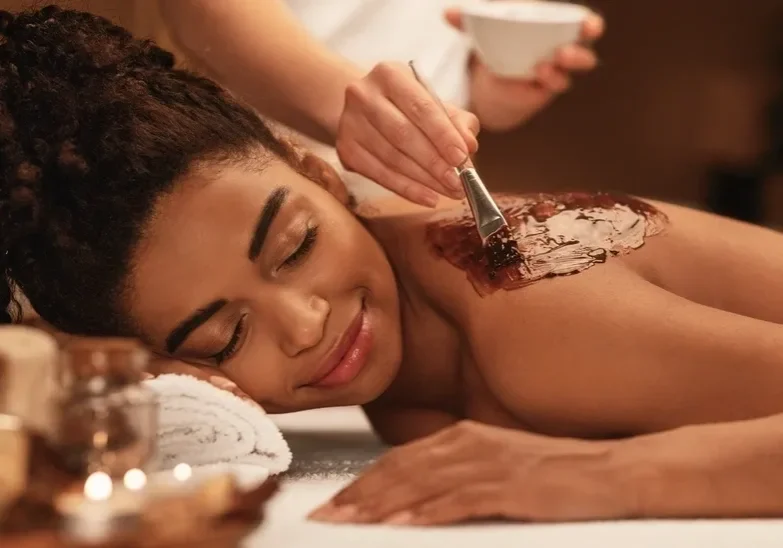 A woman getting chocolate covered on her back