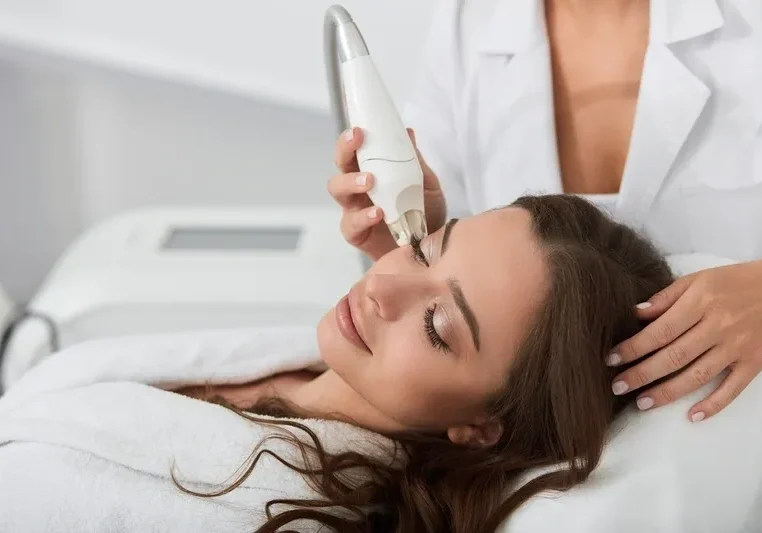 A woman getting her hair brushed by a man.